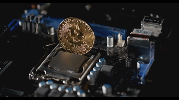 Gold Bitcoin With Motherboard Rotates On The Table. New Crypto Currency, Bitcoin And Computer Fee