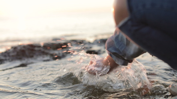 A Little Girl Splashing Sea Water by the Seacoast