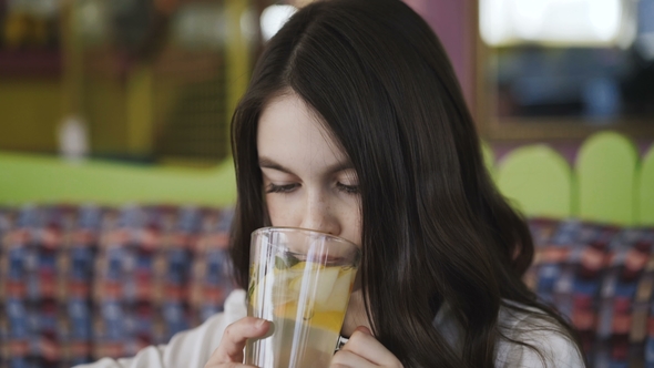Beautiful Girl Drinks Lemonade and Smiling at Camera
