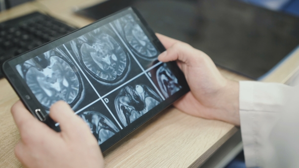 A Doctor Who Is Observing a Patient's MRI Examination