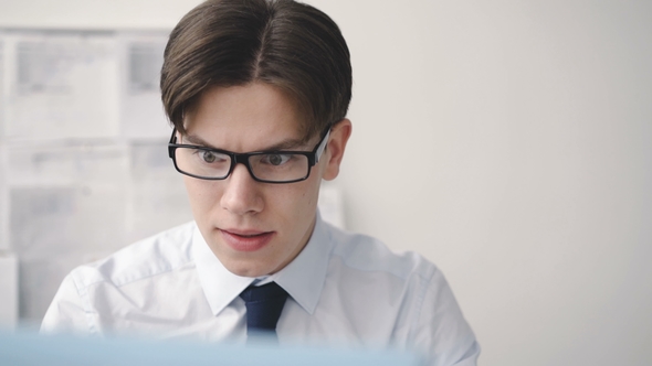 Worried Businesman Works with Computer in Office