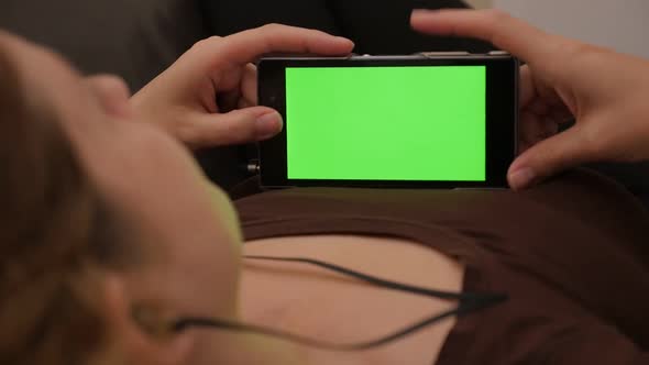 Woman Listening music on smart phone with green screen slow motion 1080p FullHD  footage - Chroma gr