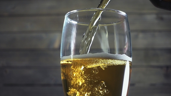 Beer Poured in Glass on Wood Background