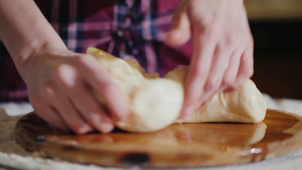 - Hands Knead the Dough on a Wooden Board The Board Is Oiled with Vegetable Oil