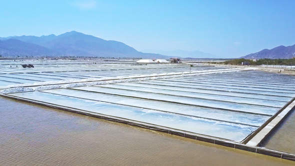 Salt Fields Flooded with Seawater against Hills