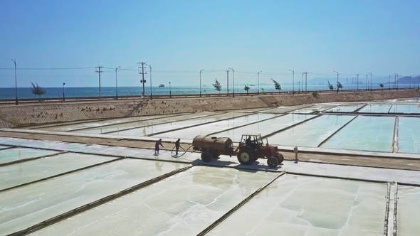 People Work on Salt Fields Pouring Water from Tank