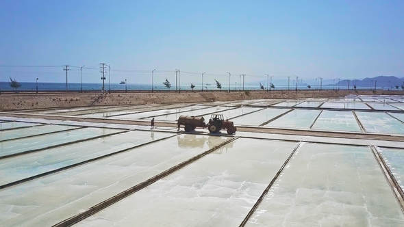 Tractor with Cistern Drives among Vast Salt Fields