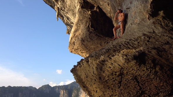 Brave Adventurist Man Is Playing Hapr Barefoot on the Slope of Sharp Island Limestone Cave in the