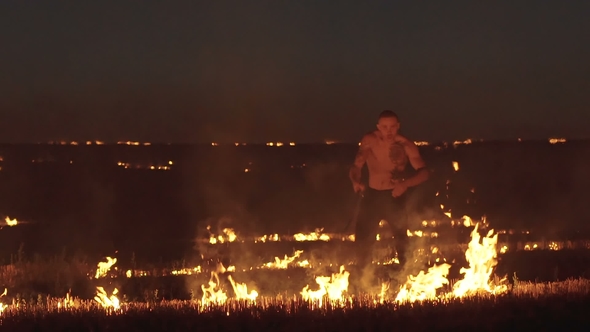 Free Fighter Training with Sword in the Burning Night Field. Slowly