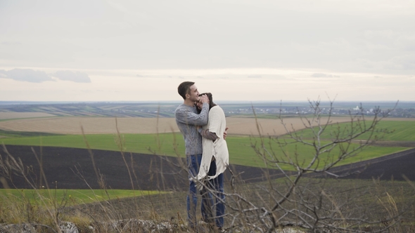 Romantic Couple in Embracess and Kisses Stand on the Top of Rock