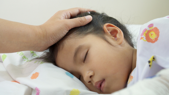 Young Mother is Touching Head of Sick Daughter