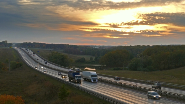 Cars Traveling on the Highway Road at Sunset,