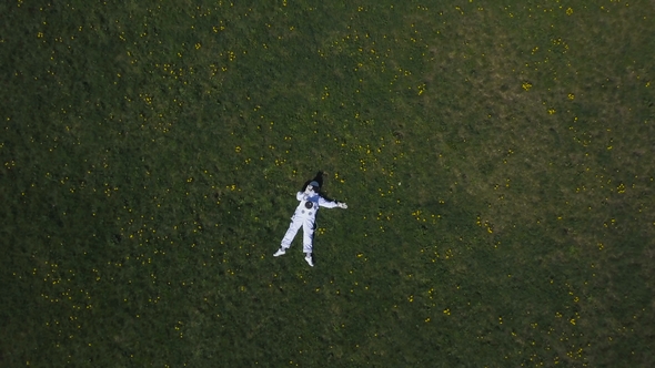 Astronaut Lying on the Grass Looking at the Sky