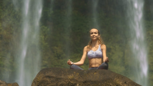 Girl Does Breathing Exercise against Waterfall