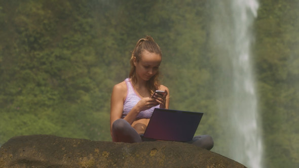 Woman with Computer Reads Text Messages on Stone