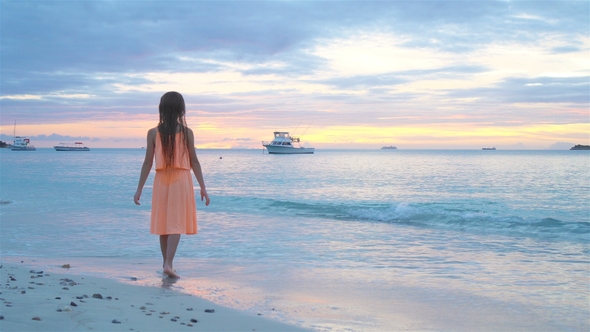 Adorable Happy Little Girl on White Beach at Sunset