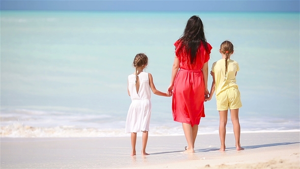 Young Beautiful Mother and Her Adorable Little Daughter Have Fun at Tropical Beach