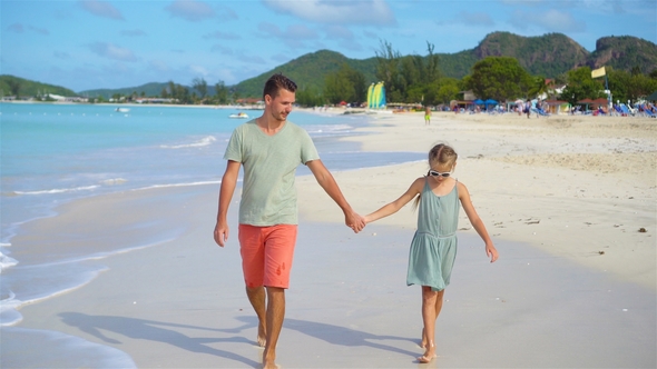 Happy Father and His Adorable Little Daughter at Tropical Beach Walking Together