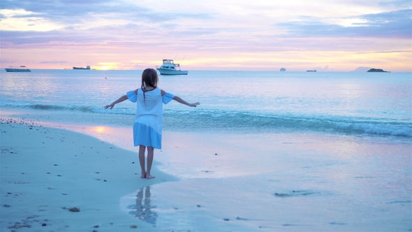 Adorable Happy Little Girl on White Beach at Sunset