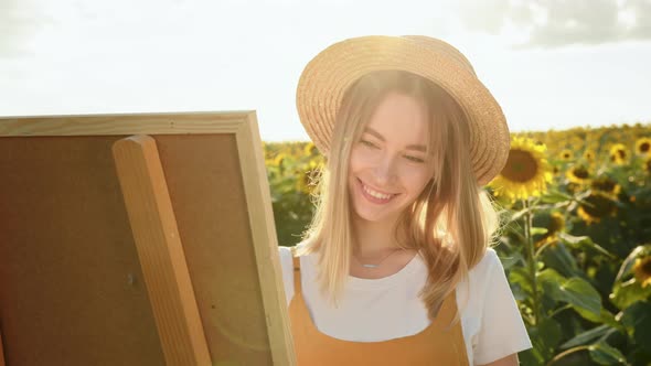 A Woman is Standing in a Field of Sunflowers and Drawing a Picture