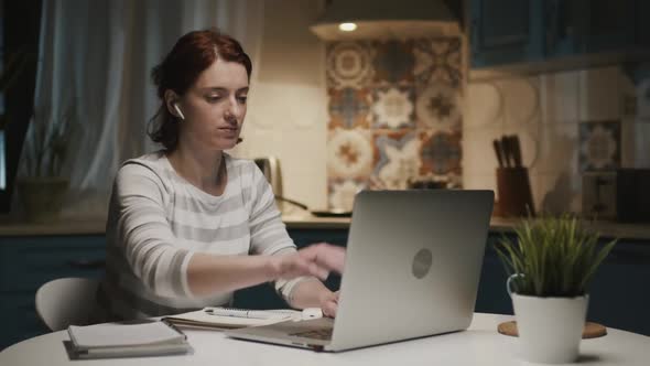 Woman In The Kitchen With Laptop, She Closes Her Laptop And Leaves The Kitchen