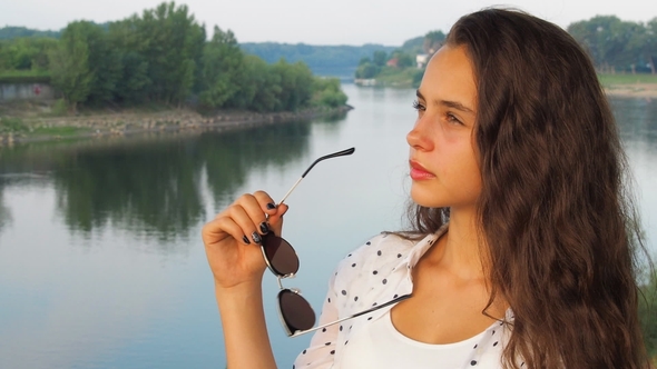 Beautiful Girl in the Background of a River Landscape