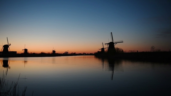 Traditional Dutch Windmills at Sunset From the Channel Rotterdam. Water Mirror Effect. Holland