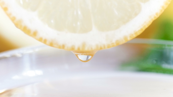 Footage of Juice Dropping From Fresh Lemon Slice in Jar