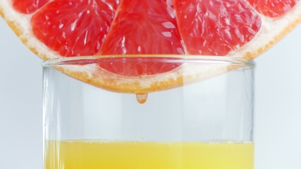 Footage of Juice Droplets Flowing in Glass From Grapefruit or Red Sicilian Orange