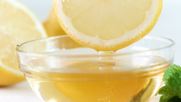 Footage of Bee Honey Dripping From Lemon Slice in Jar