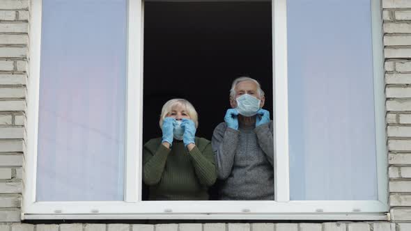 Old Grandparents Stay at Window Isolated at Home on Quarantine. Coronavirus