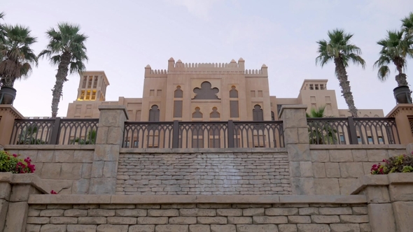 Arabian Palace with Authentic Stone Fence in Twilight with Palm Garden and Flowerbeds