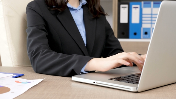 of Businesswoman Hands Typing on Laptop