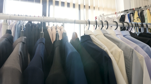 Hangers Full with Different Clothes in a Store Next To a Window