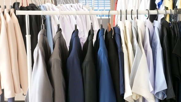 Different Male Business Clothes, Including Suits and Shirts on a Hanger