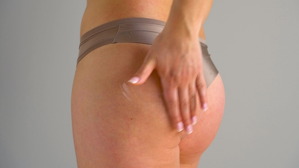 Woman Rubs Into the Skin of the Buttocks and Legs Anti-cellulite Cream