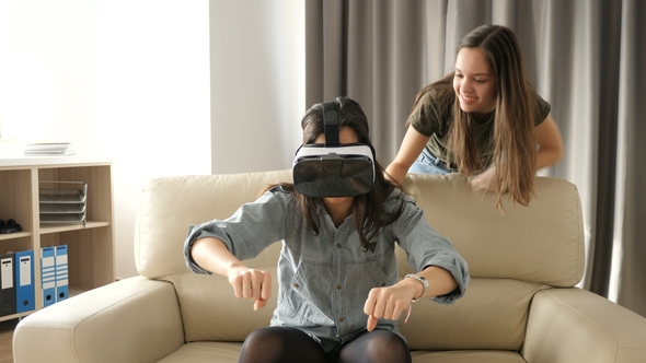 Two Sisters Having Fun with a VR Headset