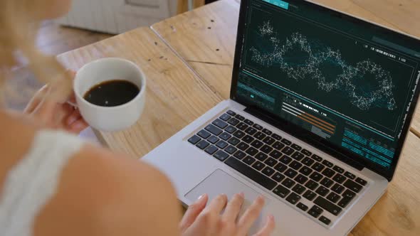 Woman with coffee cup looking at dna model on laptop