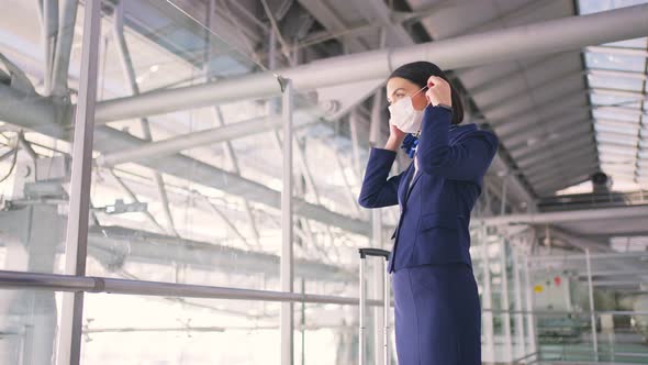 Cabin crew or air hostess wearing face mask, walk in airport terminal to the airplanel during Covid.