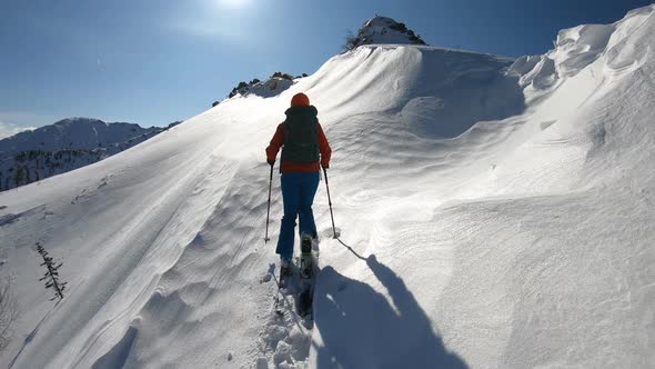 A Man on Skis in the Mountains in a Strong Blizzard Rises Up