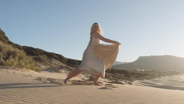 Glamourous Woman Dancing In Dress On Beach