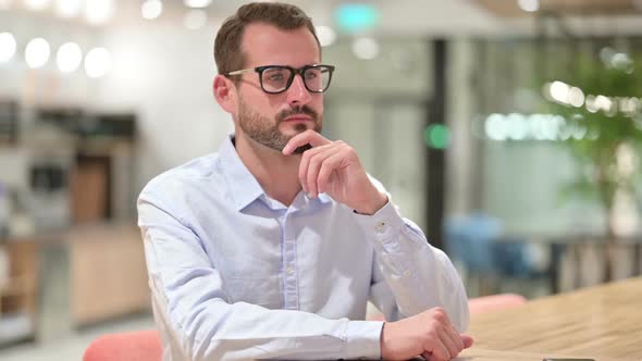 Businessman Sitting and Thinking in Office