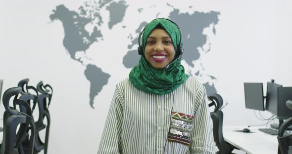 Happy Islamic Businesswoman with Hijab Wearing a Headset While Standing in the Modern Office