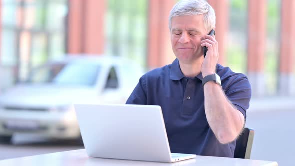 Outdoor Ambitious Middle Aged Businessman Taking on Smartphone