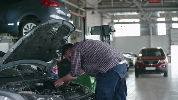 Experienced Technicians Fixing Car