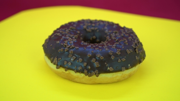 Delicious Sweet Donut Rotating on a Plate. Top View. Bright and Colorful Sprinkled Donut