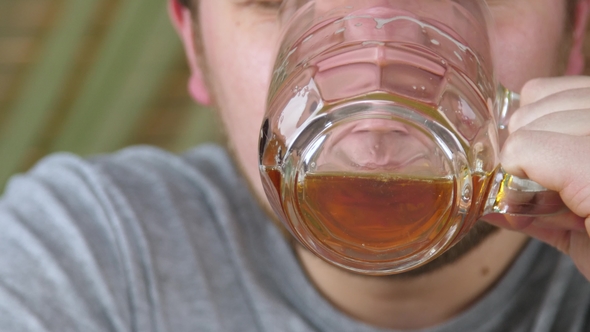 Man Drinks Beer from a Glass