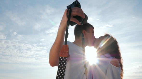 Man Takes Pictures of His Beloved Girl on the Seashore in Spring. Photoshoot of Beautiful Couple on
