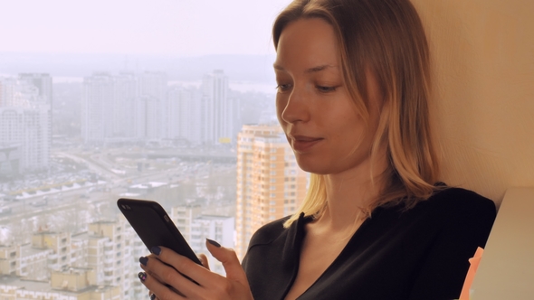 Young Lady Messaging on Smart Phone at Home or Office