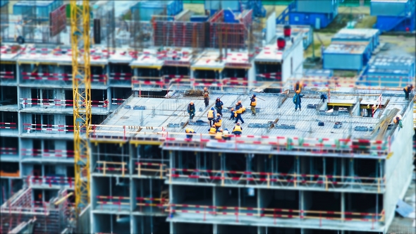 Tilt Shift Builders and Cranes Working on the Construction Site